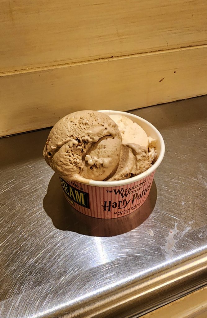 One scoop of salted caramel blondie and one scoop of apple crumble ice cream in a small Harry Potter Wizarding World labeled cup.