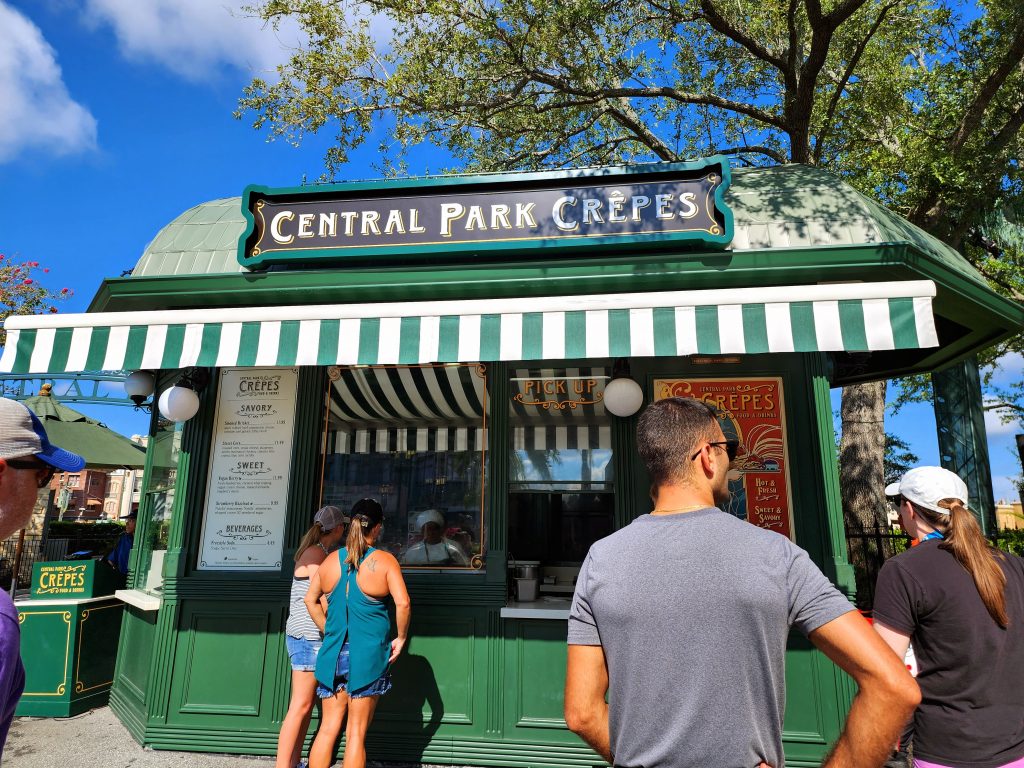 A green stand where employees make and sell fresh crepes.