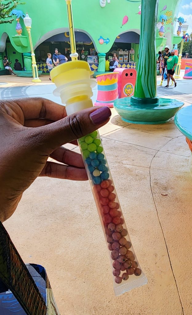 A plastic tube filled with tiny colorful sour candy.