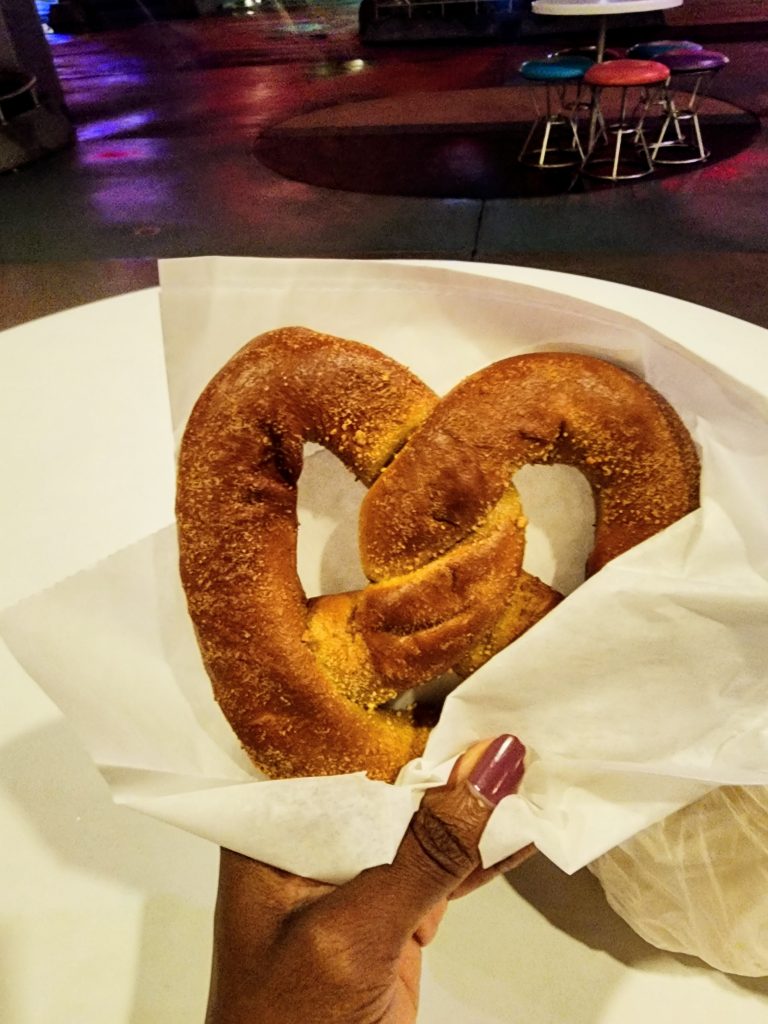 A pretzel stuffed with cream cheese held in a napkin.