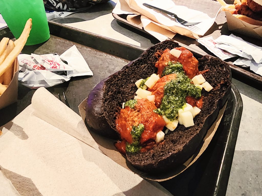 Meatballs and mozzarella cheese chunks smothered in marinara and pesto sauces atop of black-dyed bread.