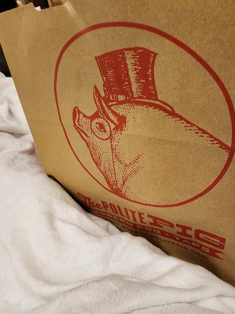 A brown bag labeled for the barbecue restaurant Polite Pig.