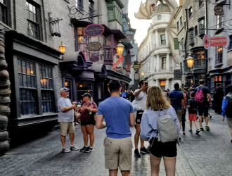 Diagon Alley at Universal Studios Florida: A busy street with colorful shops and awnings, with an animatronic dragon atop a fake bank building.