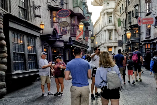 Diagon Alley at Universal Studios Florida: A busy street with colorful shops and awnings, with an animatronic dragon atop a fake bank building.